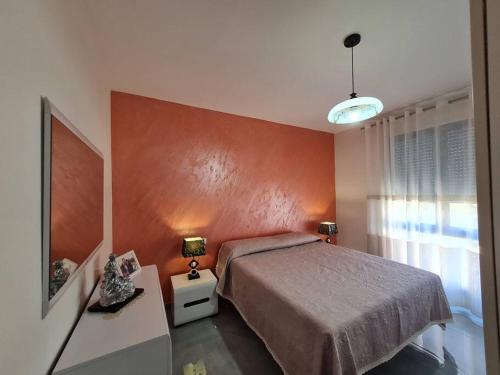 a bedroom with a bed and a red wall at Apartment Aulona Park in Vlorë