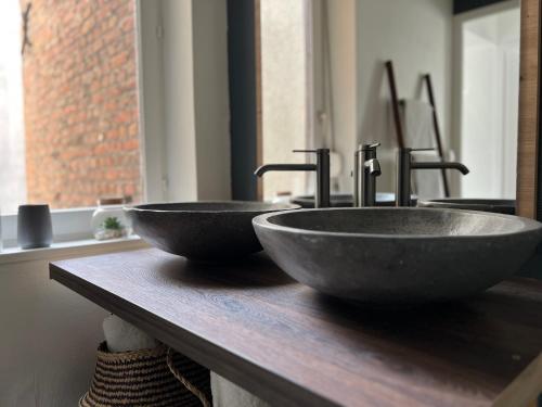 two sinks sitting on a counter in a bathroom at Le Saphir de Calais - Chic et élegant in Calais
