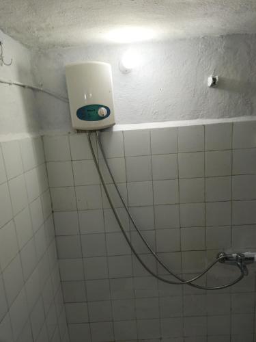a white tiled bathroom with a light on the wall at daily rental apartment 5 minutes to the airport in Pazar