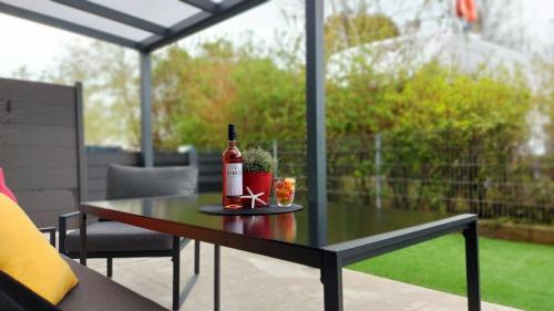 a bottle of wine sitting on a table on a patio at Kikötő Sétány Apartman I. in Balatonszemes