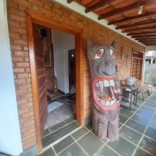 a wooden bear statue on the side of a house at Casa para Aluguel de Temporada - Carrancas MG in Carrancas