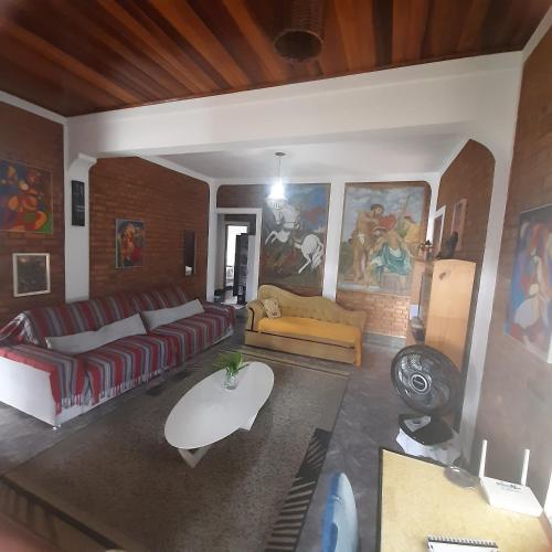Casa para Aluguel de Temporada - Carrancas MG في كارانكاس: غرفة معيشة مع أريكة وطاولة