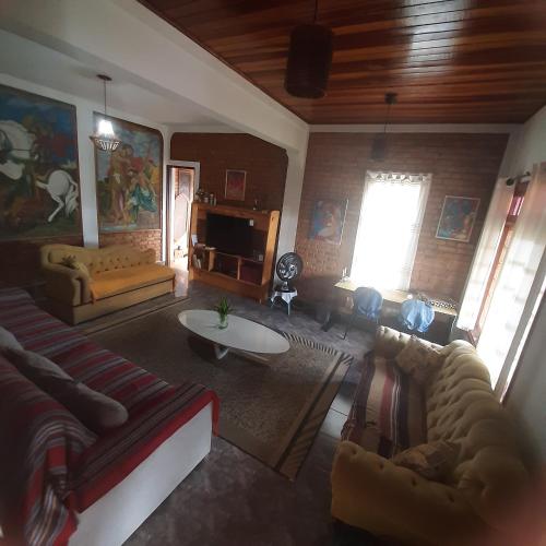 a living room with a couch and a table at Casa para Aluguel de Temporada - Carrancas MG in Carrancas
