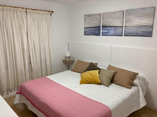 um quarto com uma cama com quatro almofadas em La Terraza em Los Cancajos