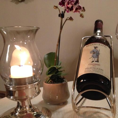 a bottle of wine and a candle on a table at Casa Bona in Alba