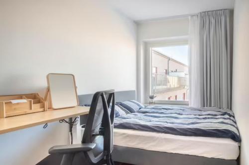 a bedroom with a bed and a desk and a window at Private room in Hammarby Sjöstad, common space shared! in Stockholm