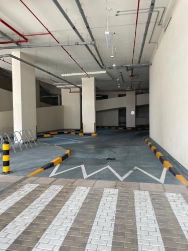 an empty parking garage with white and yellow lines on the floor at New Reva Hotel Apartment next Burj Khalifa in Dubai