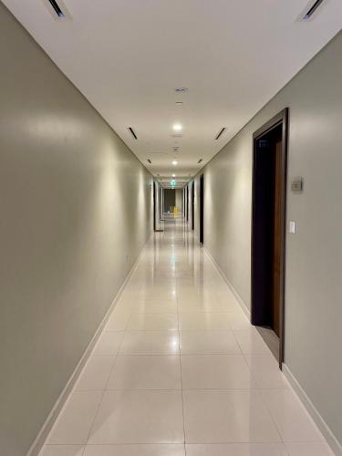 a long hallway with white floors and a long corridor at New Reva Hotel Apartment next Burj Khalifa in Dubai
