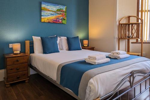 a bedroom with a large bed with towels on it at The Coo's Guest House in Inverness