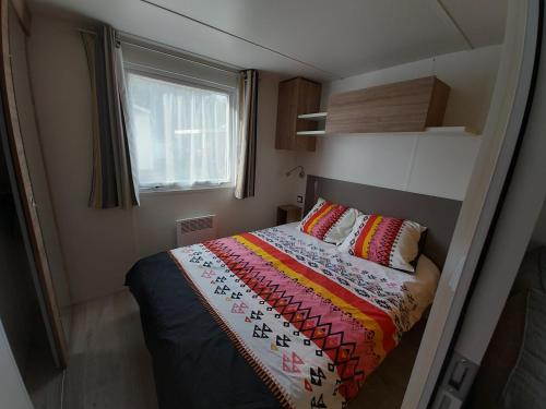 a small bedroom with a bed and a window at Location mobile home 6 personnes a fréjus in Fréjus