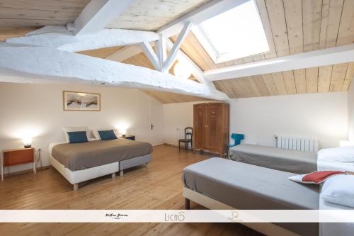 a attic bedroom with two beds and a skylight at Le Nid des Anges, votre studio à la campagne. in Saint-Laurent-du-Plan