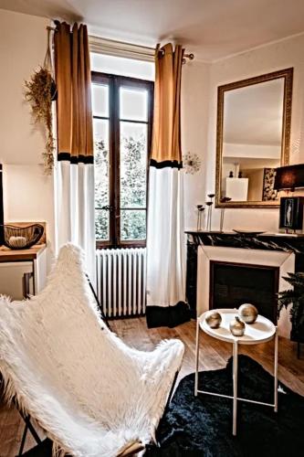 - un salon avec une chaise et une cheminée dans l'établissement BELLE REINE - 3 APPARTEMENTS EN COEUR DE CENTRE-VILLE, à Aix-les-Bains