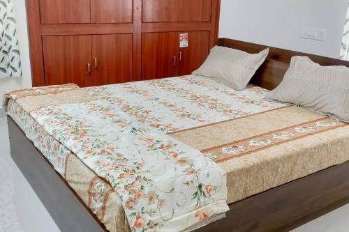 a bedroom with a large bed with a wooden cabinet at 2 Bhk Fully Furnished Hafeezpet #101 in Hyderabad