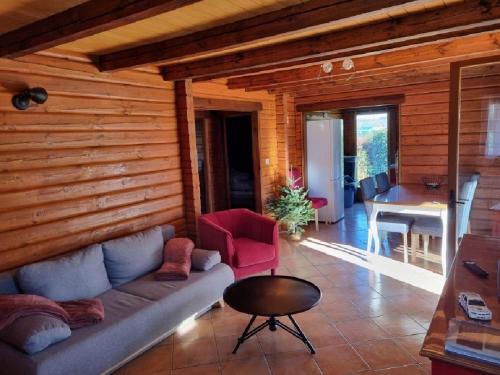 a living room with a couch and a table at Le Chalet de la Dordogne in Mauzac-et-Grand-Castang