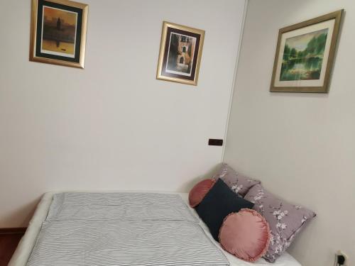 a bed in a room with two pictures on the wall at Apartment Luci near Bacvice beach in Split