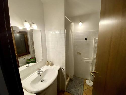 een witte badkamer met een wastafel en een douche bij Casetta in Campagna Fiorano in Poggio Catino