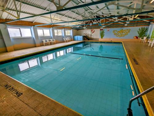 a large indoor swimming pool with blue water at 35 Gower Holiday Village in Reynoldston
