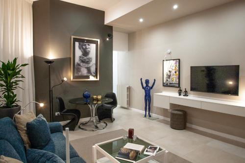 sala de estar con sofá azul y TV en La Chimera Luxury Home en Taranto