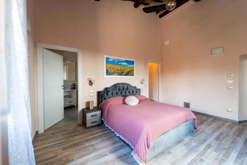 een slaapkamer met een bed met een roze deken bij Casale Il Terranova in Cortona