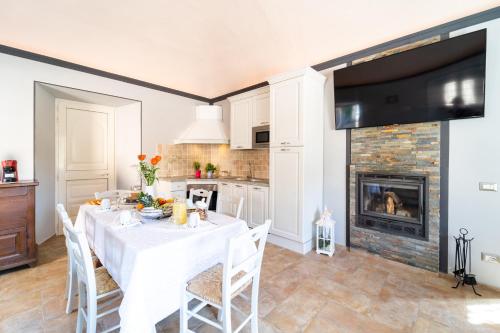 ein Esszimmer mit einem Tisch und einem Kamin in der Unterkunft Casale Il Terranova in Cortona