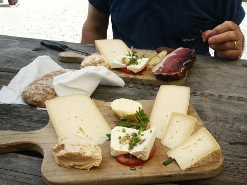 a cutting board with cheese and bread on a table at Pension Pernthaler in Silandro