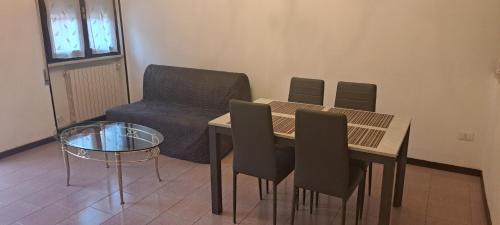 un soggiorno con tavolo, sedie e divano di CASA DELLA NONNA a Bagnolo Mella