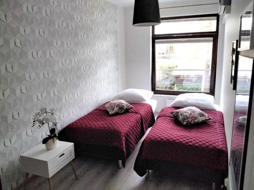 a bedroom with two beds and a window at Apartament Kasztanowy in Władysławowo