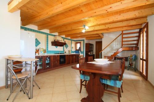 a kitchen and dining room with a wooden ceiling at Casa sulla collina - Sant'Antioco in SantʼAntìoco