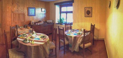 a dining room with two tables and a kitchen at Casa Rural Areano in Escoriaza