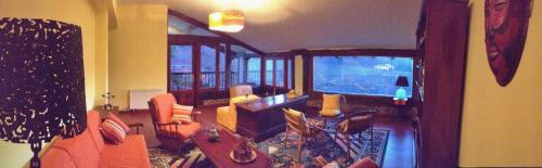 a living room with orange chairs and a guitar at Casa Rural Areano in Escoriaza