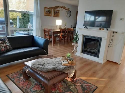 a living room with a couch and a fireplace at Gastehuisie Lekkerslaap in Zeewolde