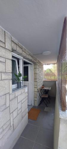 a patio with a stone wall and a window at Apartma Licko in Domžale