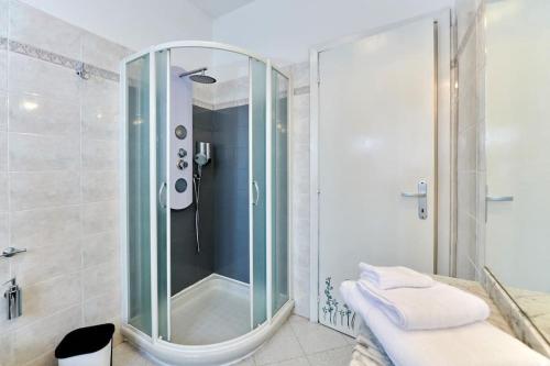 La salle de bains est pourvue d'une douche avec une porte en verre. dans l'établissement Le Betulle, à Borgo Ticino
