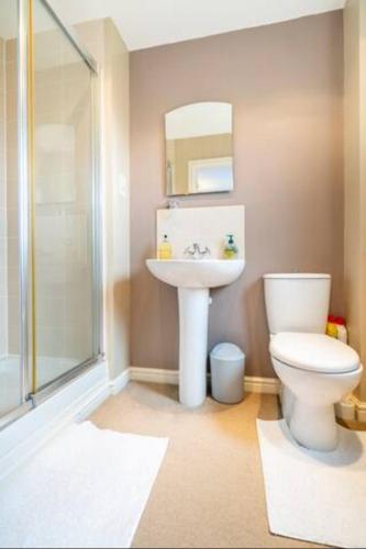 a bathroom with a toilet and a sink at Bulkington Lodge Coventry - Affordable Cosy Double & En-Suite Rooms in Bulkington