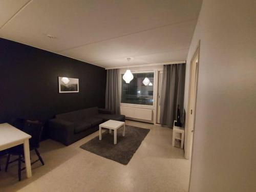 - un salon avec un canapé et une table dans l'établissement Saunallinen kaksio, à Tampere