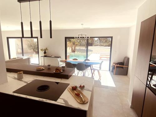 a kitchen and living room with a table and chairs at Villa moderne entre centre ville et nature in Nîmes