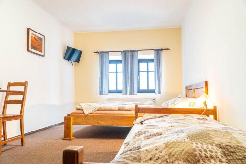 a bedroom with two beds and a window at Penzion Jedlová in Jiřetín pod Jedlovou