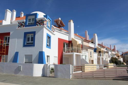 un gran edificio blanco con rojo y azul en Carlota House - Baleal, en Baleal