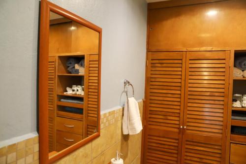 Luxurious Mid Century Modern folk art home في مدينة ميكسيكو: حمام مع خزانة خشبية ومرآة