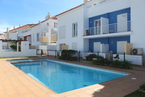 a villa with a swimming pool in front of a building at Carlota House - Baleal in Baleal