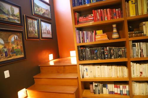 a book shelf filled with books next to a staircase at Luxurious Mid Century Modern folk art home in Mexico City