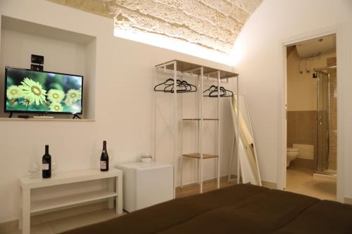 ein Schlafzimmer mit einem Bett und einem TV an der Wand in der Unterkunft Al Guiscardo 8 in Bari
