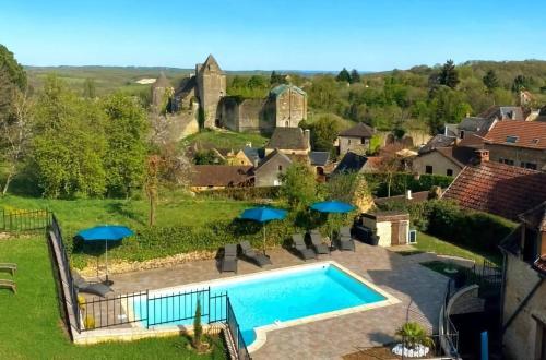 une vue aérienne d'une maison avec piscine dans l'établissement Le Clos de la Musardise - Gîtes de Charme avec Piscine Chauffée, à Salignac Eyvigues