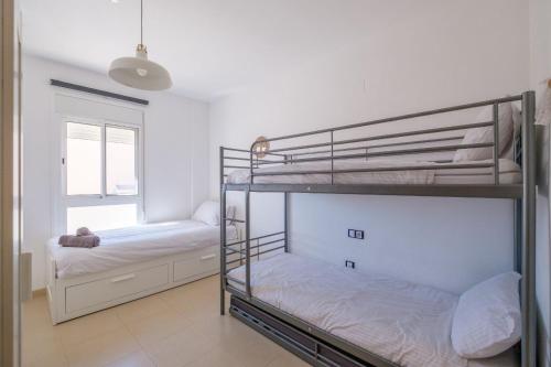a bedroom with two bunk beds and a window at Apartamento GELUM Delta del Ebro in Sant Jaume d'Enveja