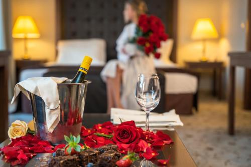 a table with a bottle of wine and flowers on it at Maxi Park Hotel & Spa in Velingrad