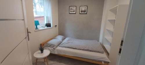Dormitorio pequeño con cama pequeña y lavamanos en Apartament 4YOU en Pobierowo