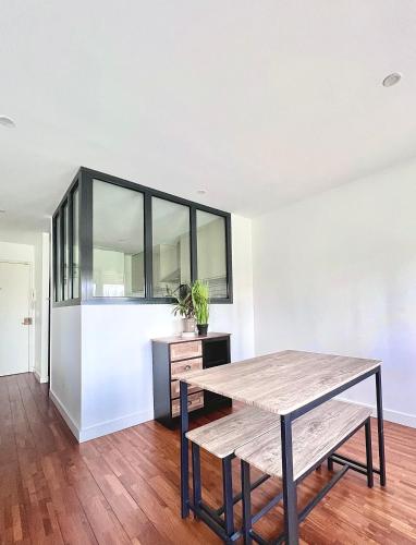 une salle à manger avec une table et un banc dans l'établissement Bel appartement complet:, à Villetaneuse