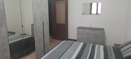 1 dormitorio con cama, tocador y espejo en CASA DELLA NONNA en Bagnolo Mella