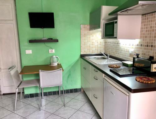 ベルガモにあるApartment Bergamo Centro Storicoの緑の壁のキッチン(小さなテーブルと椅子付)