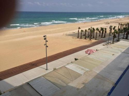 Blick auf einen Strand mit Palmen und das Meer in der Unterkunft Cozy 2-bedrooms with balcony 20 in Bat Yam